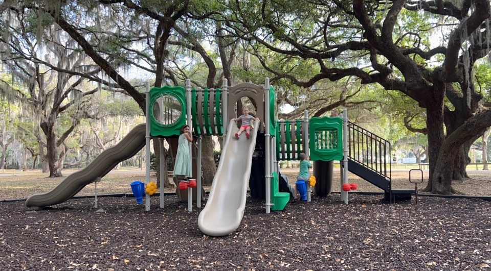 6 simple ways to improve your child’s learning environment Children playing on outdoor playground slide in park setting