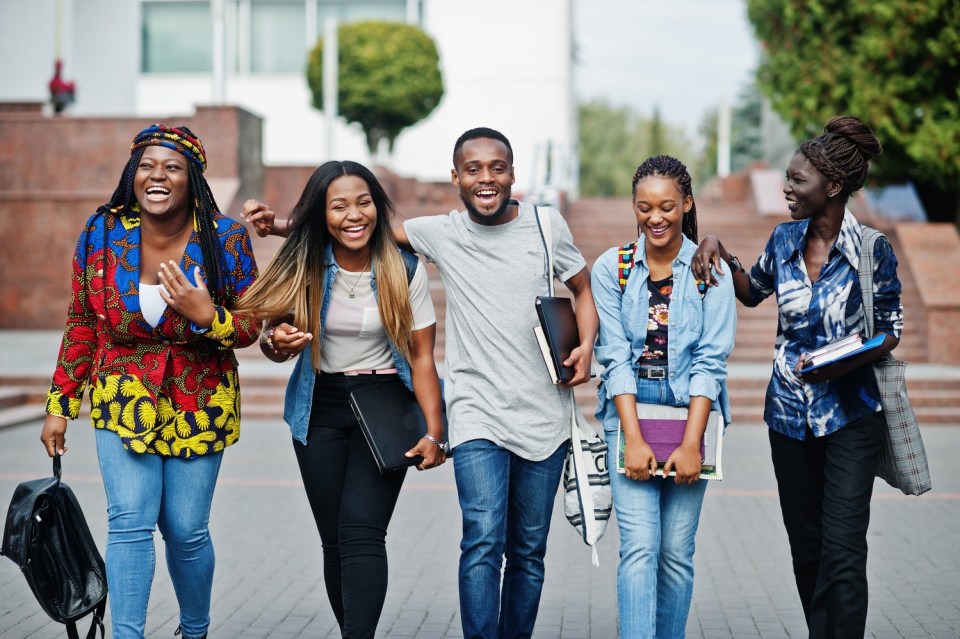 How to help college kids thrive on their own College kids walking down the street on campus for an article about how to help college kids thrive on their own
