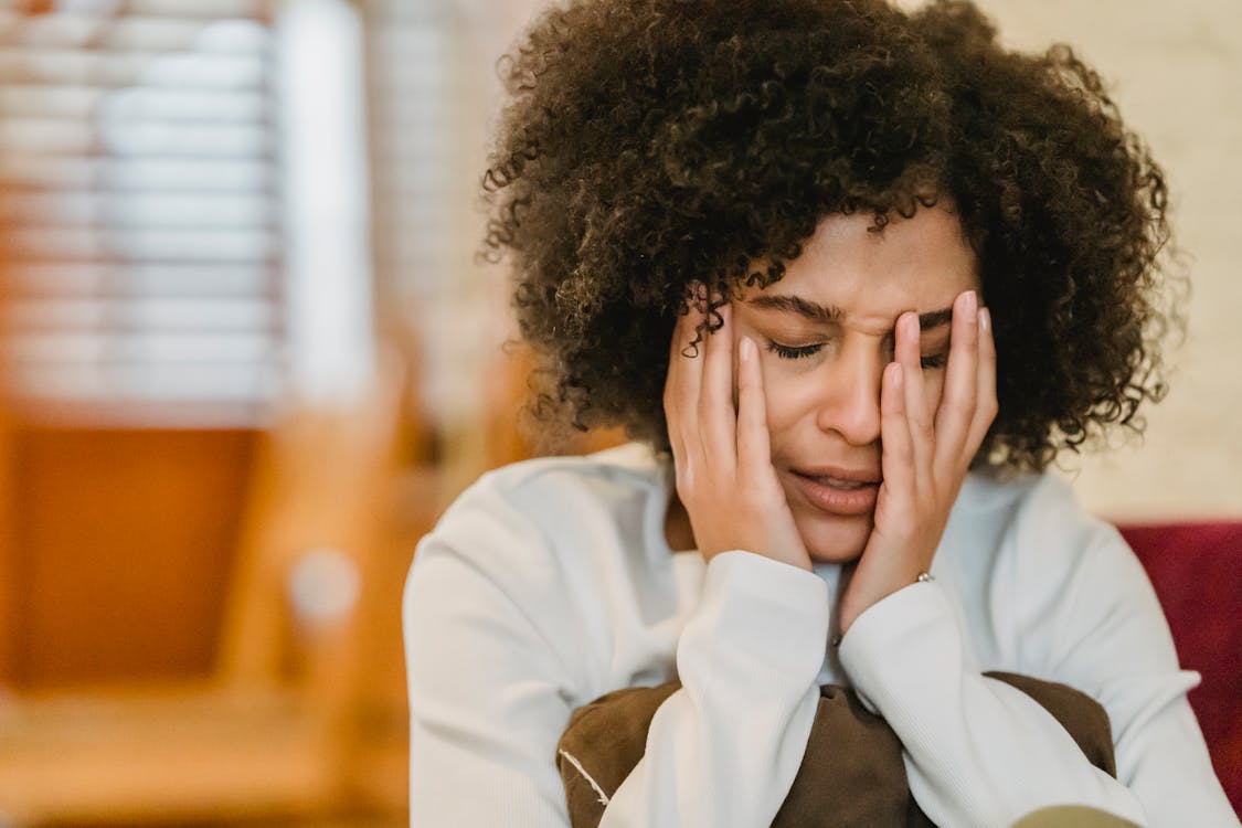 What every black parent should know about bipolar disorder A black mother sits in distress with her head in her hands, illustrating emotional struggle and mental health awareness. This image represents the silent battles many black parents face while navigating bipolar disorder in the family.