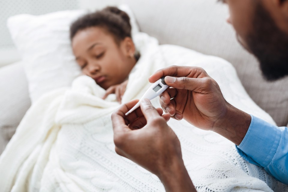 Walking pneumonia is on the rise: what black parents need to know An african american dad takes the temperature of his daughter with walking pneumonia.