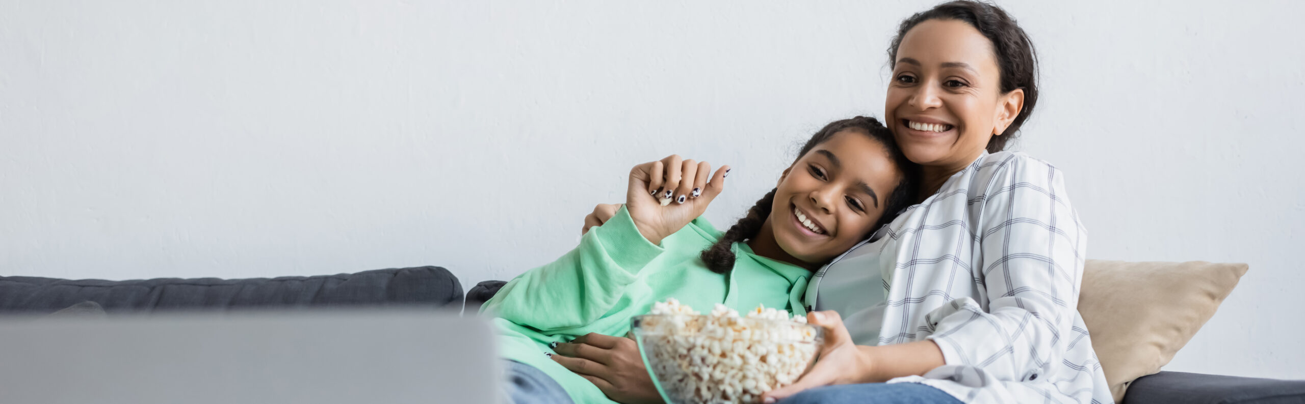 Best uk proxy servers for streaming for parents abroad An african american mom and daughter enjoy watching a movie on their laptop while abroad as expats for an article on best uk proxy servers for streaming for parents abroad