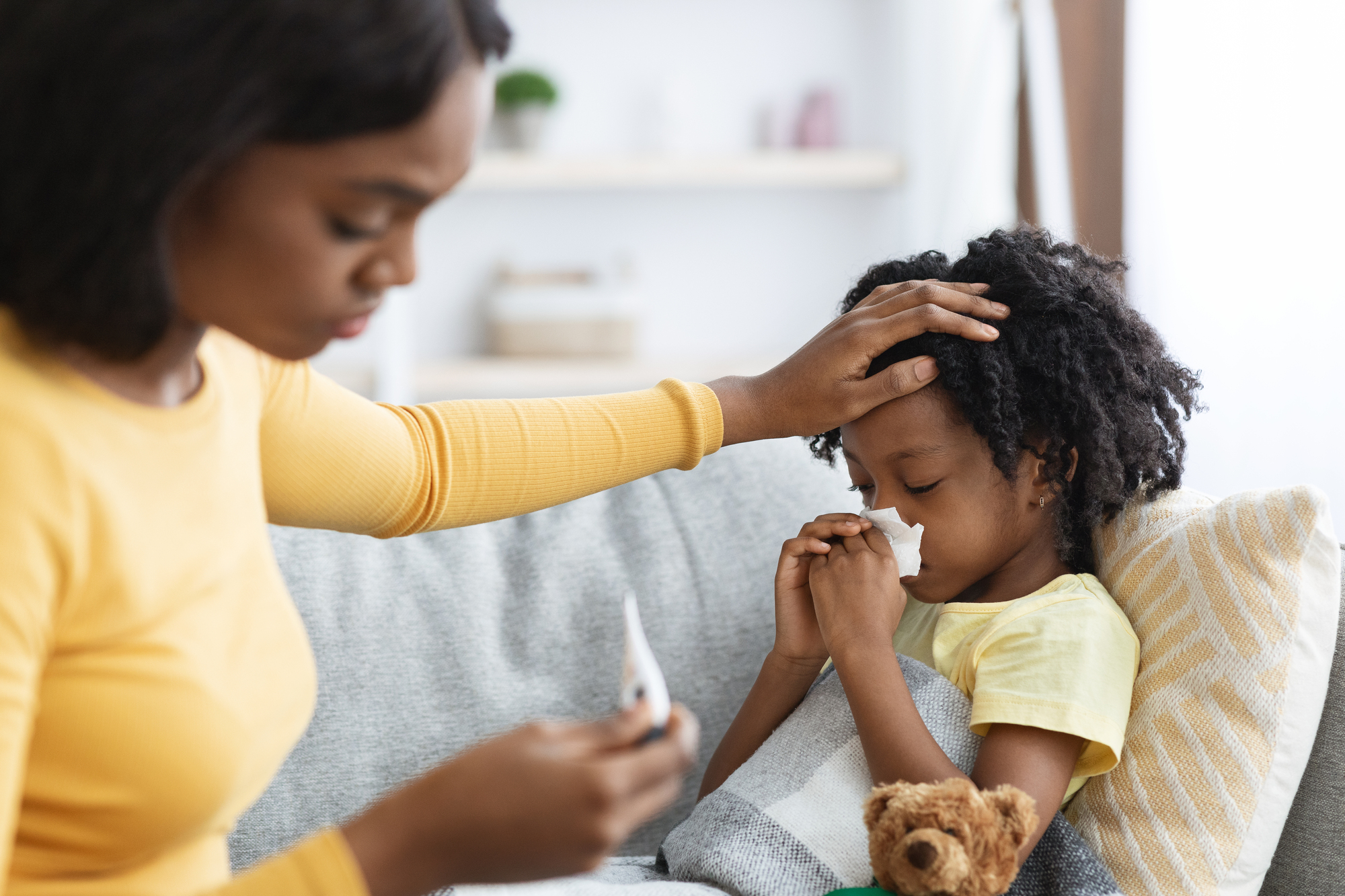 Walking pneumonia is on the rise: what black parents need to know An african american mom caring for her sick child with walking pneumonia.