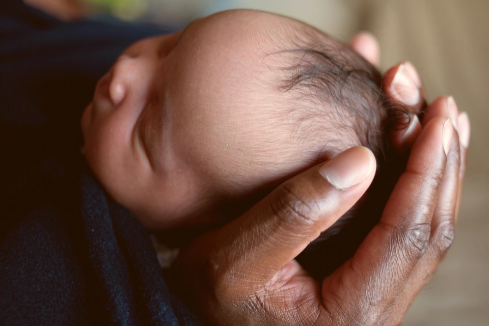 Understanding antibody vulnerability period: crucial immune health information for babies every parent should know An african american newborn baby cradled in his mother's hands for an article about immune health