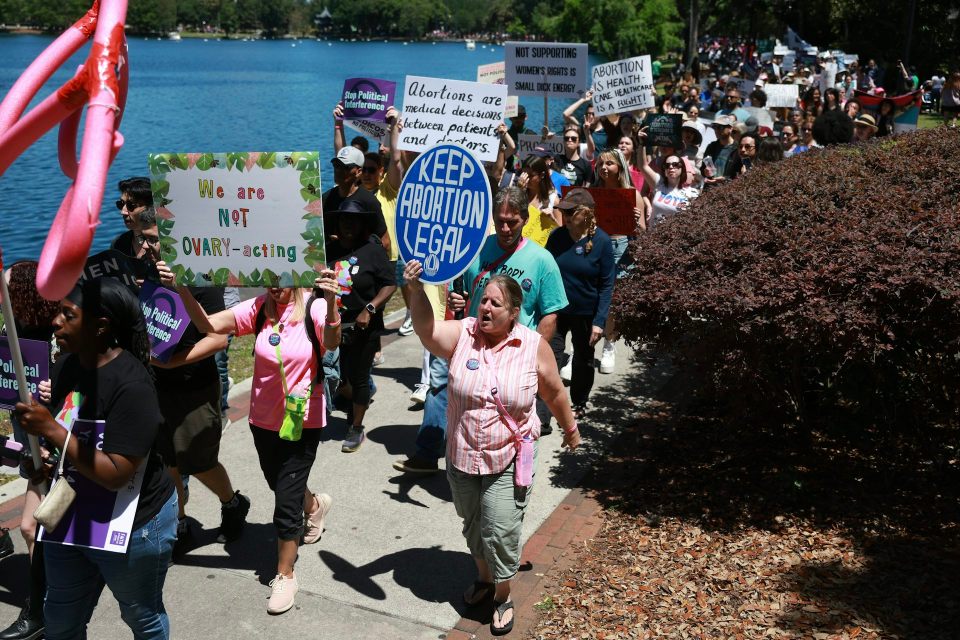 Confusion over how pregnancy dates are measured is widespread – and makes for uninformed debate over abortion limits People walk as a group in front of water and hold signs that say 'keep abortion legal. '