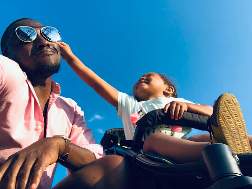 What are some hallmarks of great parenting? An african american dad playing with his child for great parenting.
