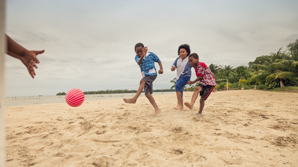10 breathtaking family-friendly travel destinations worldwide Black family playing joyfully on a beach in costa rica, perfect for family-friendly travel.