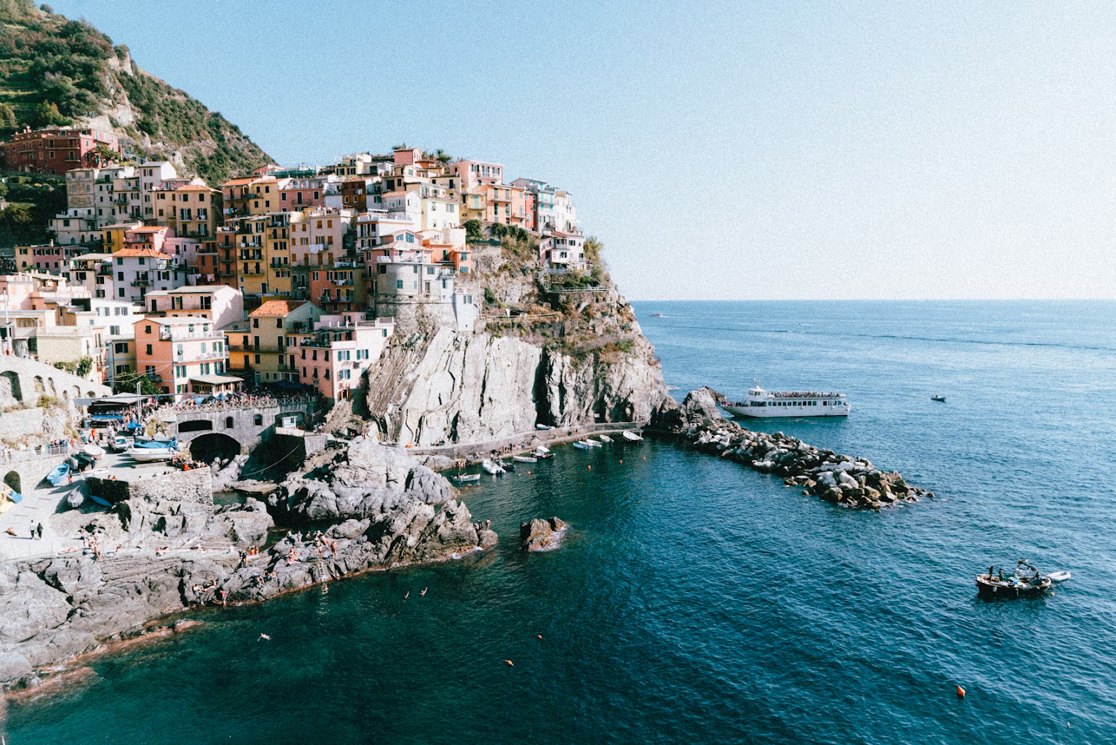 Hidden gems of europe: 10 underrated cities that will steal your heart A panoramic view of a colorful coastal village in europe, with pastel buildings perched on rocky cliffs overlooking the sea—representing the hidden gems of europe.
