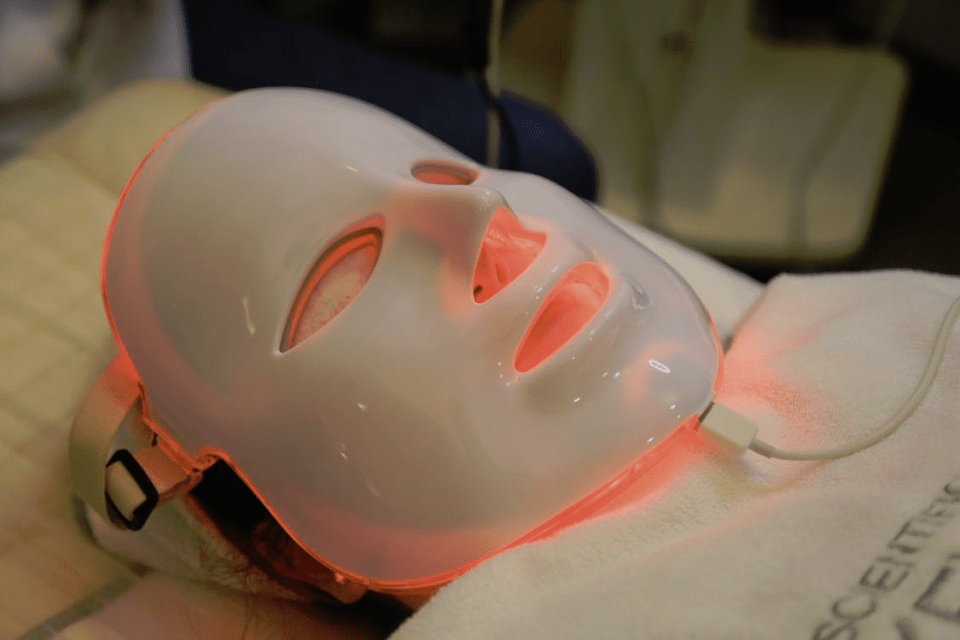 2025 hottest health & beauty trend: red light therapy - is it for you? Person undergoing red light therapy using a full-face led mask during a professional skincare session, showcasing a top 2025 beauty and wellness trend for an article titled, 2025 hottest health & beauty trend: red light therapy - is it for you?