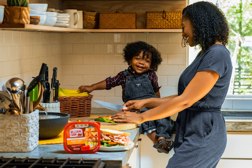 Ideas to make your kitchen more child-friendly  African american mother and child making sandwiches at the kitchen counter to make the kitchen more child-friendly