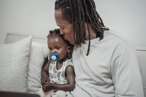 3 common childhood illnesses & how to overcome them African american dad comforts his toddler who is experiencing common childhood illnesses